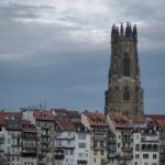 a very tall building with a clock tower in the background
